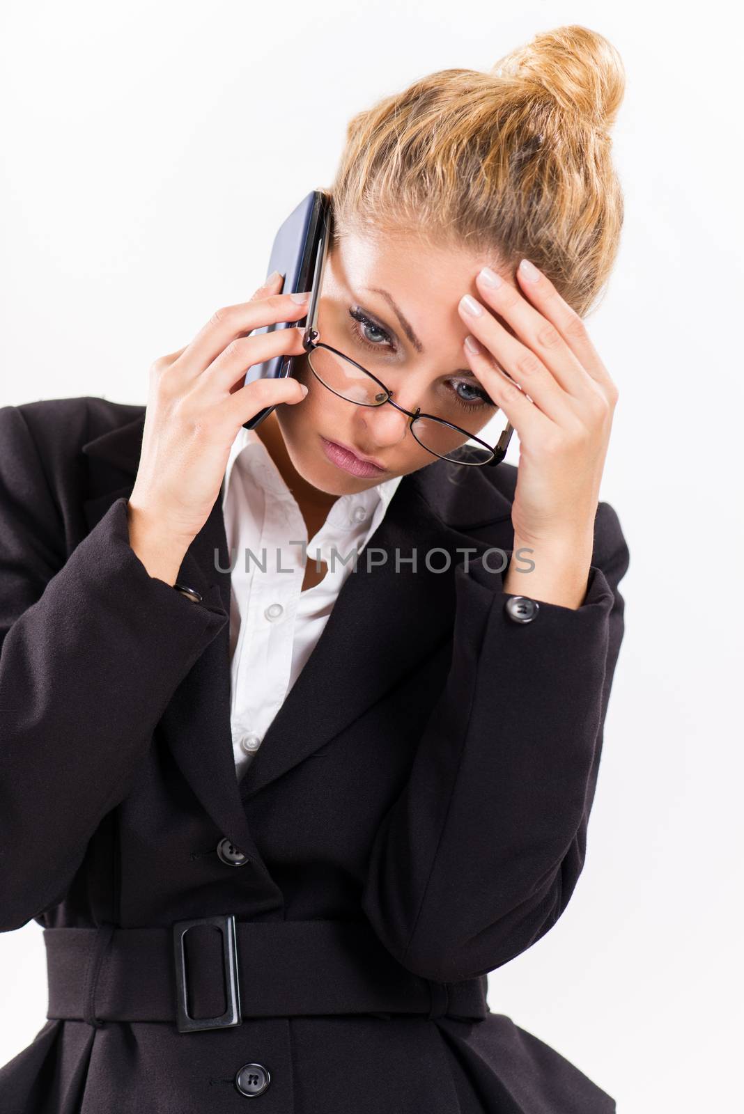 Portrait of attractive businesswoman with glasses using a mobile phone. She is thinking.