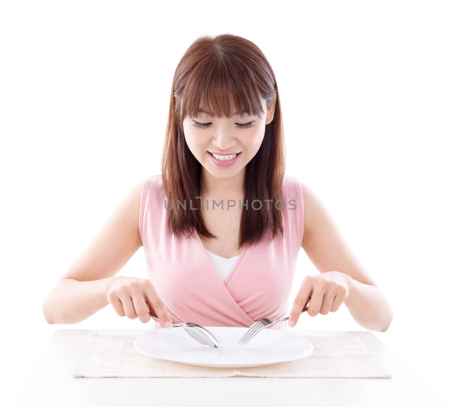 Asian girl eating with fork and spoon, empty plate ready for food. Young woman living lifestyle.