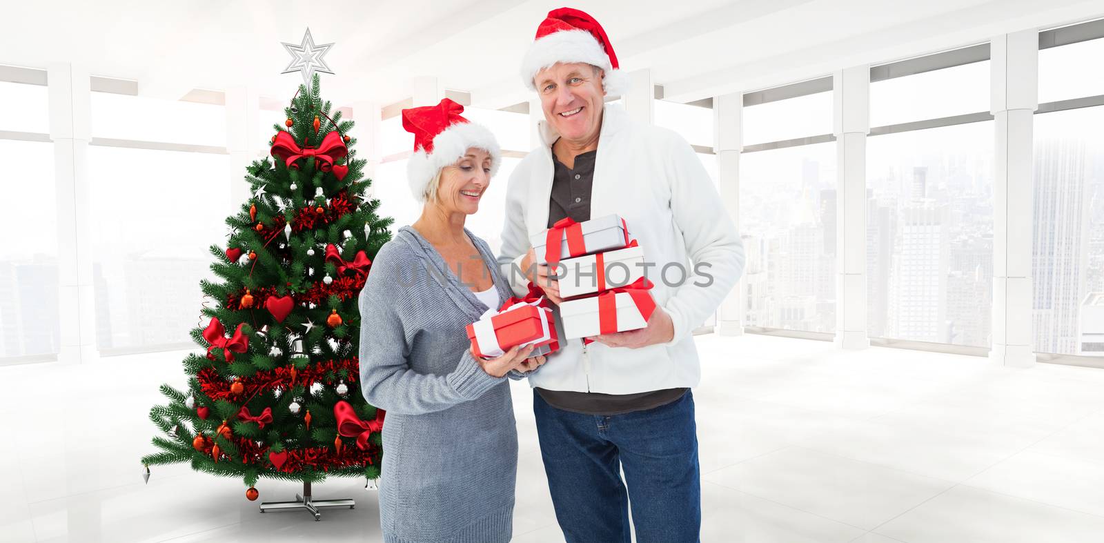 Composite image of festive mature couple holding christmas gifts by Wavebreakmedia
