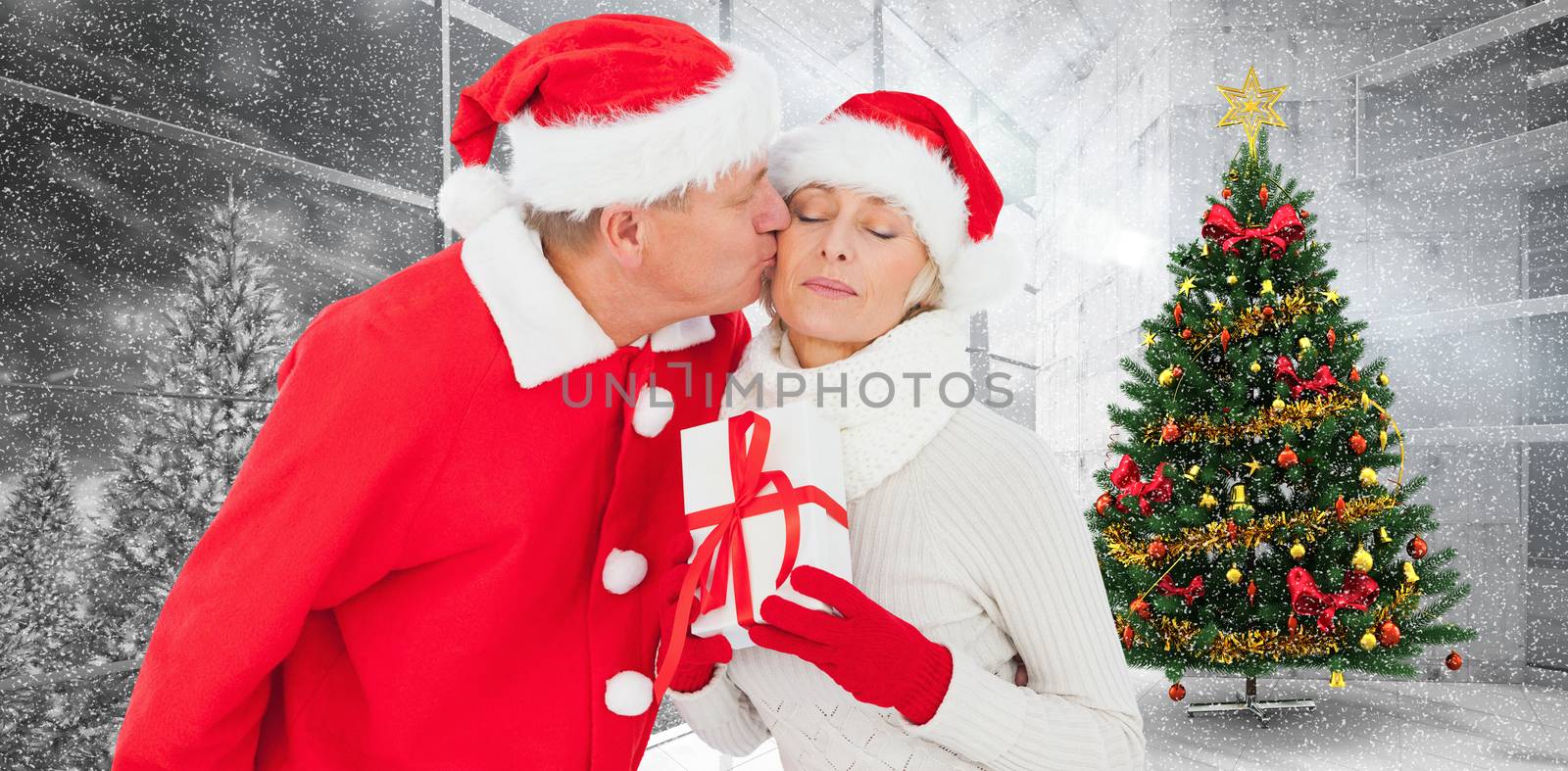 Composite image of festive mature couple holding gift by Wavebreakmedia