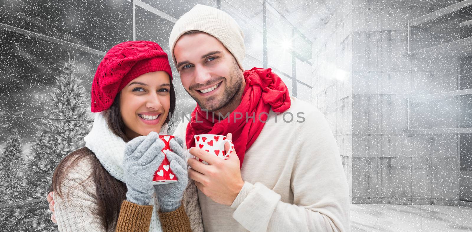 Winter couple holding mugs against window overlooking snowy forest