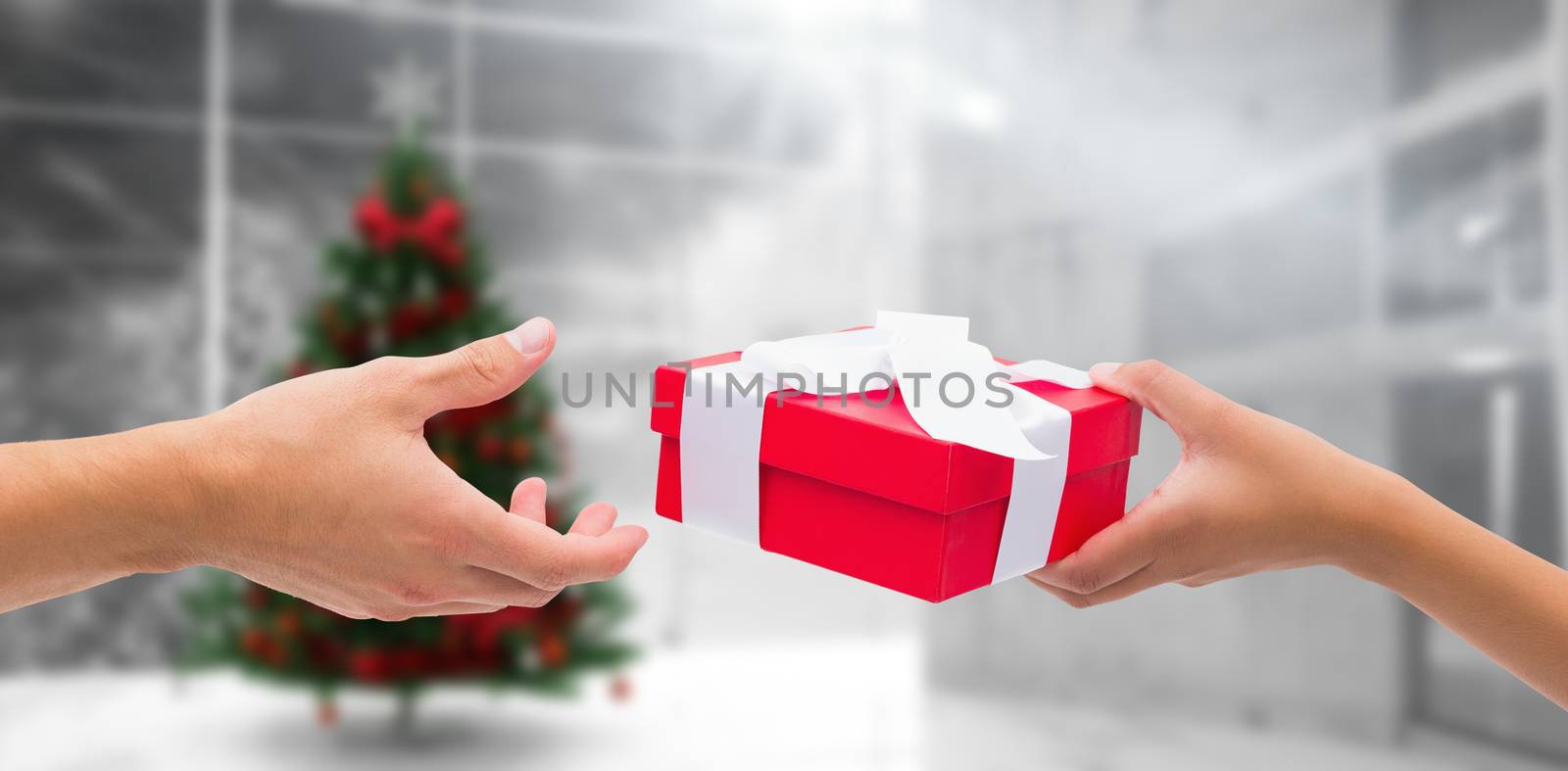 Composite image of couple passing a wrapped gift by Wavebreakmedia