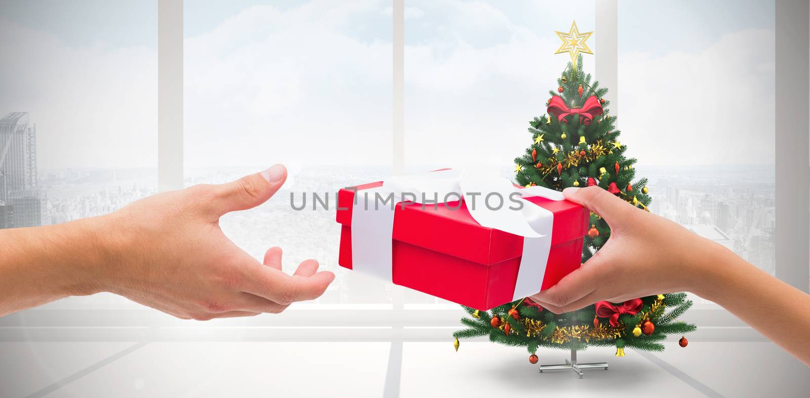 Composite image of couple passing a wrapped gift by Wavebreakmedia