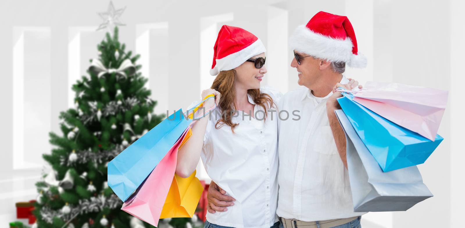 Christmas couple with shopping bags against home with christmas tree