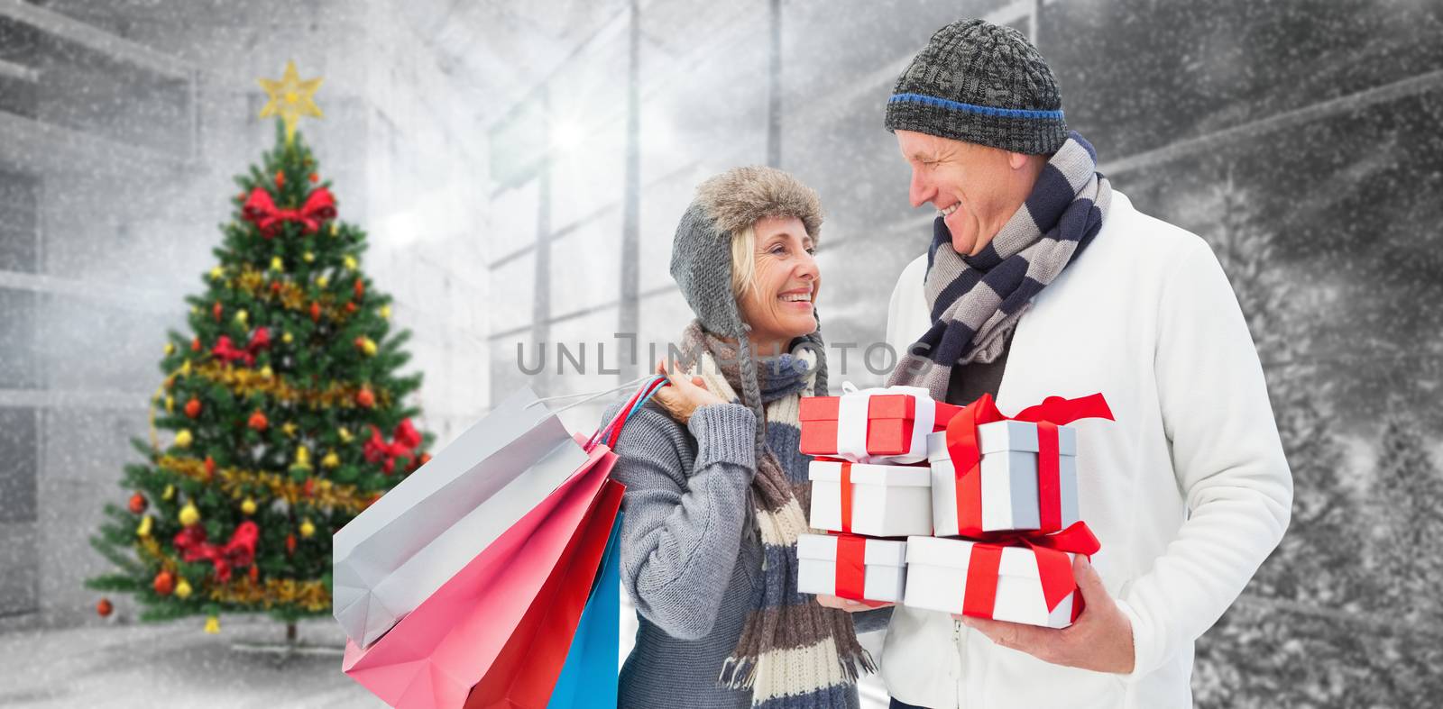 Composite image of festive mature couple holding christmas gifts by Wavebreakmedia