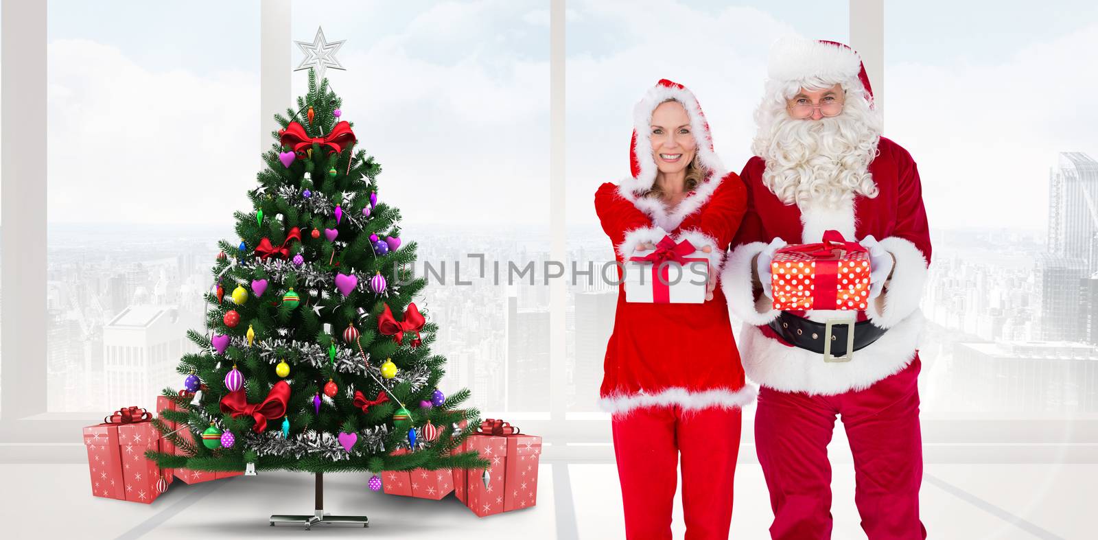 Santa and Mrs Claus smiling at camera offering gift against home with christmas tree