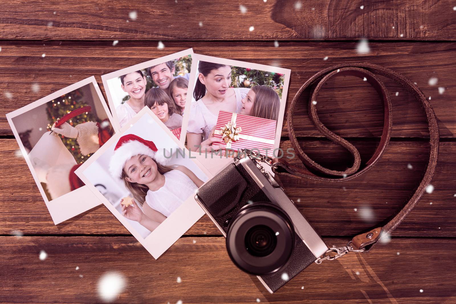 Father christmas writing with a quill against instant photos on wooden floor