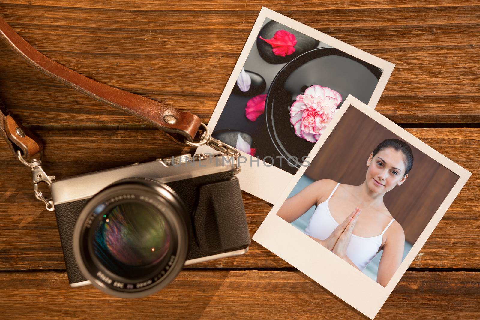 Peaceful woman in white sitting in lotus pose against white and pink carnation floating in a black bowl surrounded by black stones and petals