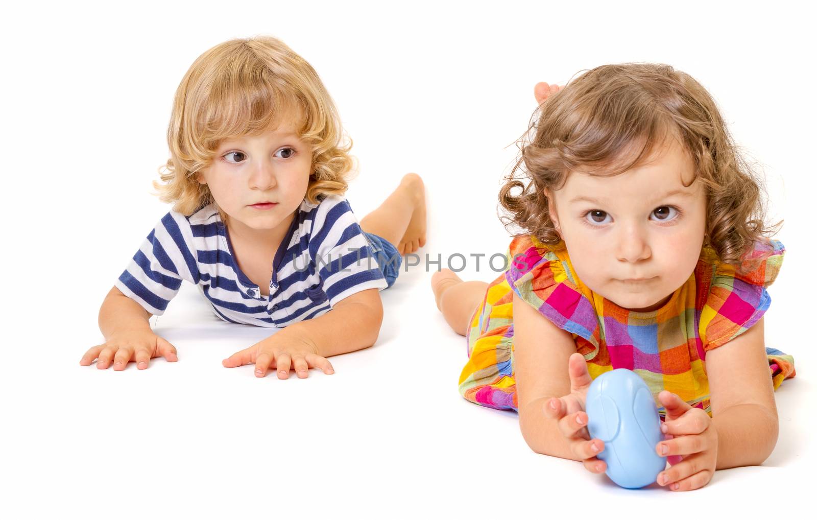 Funny boy and girl are lying together isolated on white background. Focus on little boy.