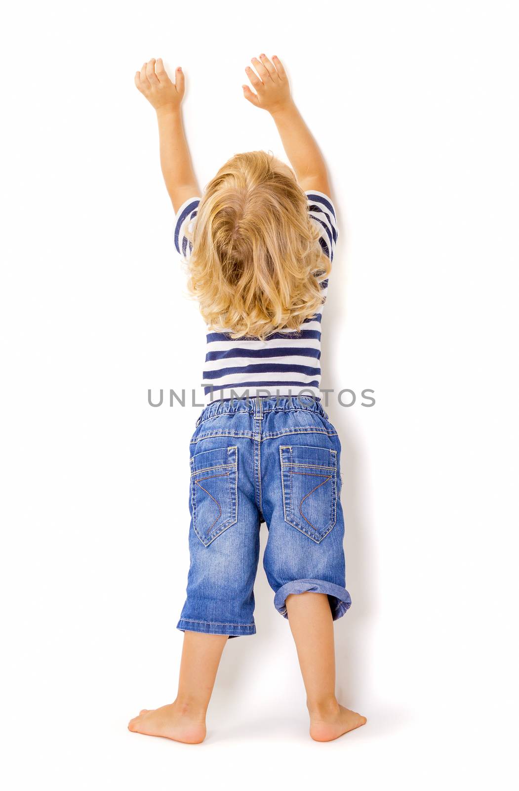 Back view of little boy with hands up by manaemedia