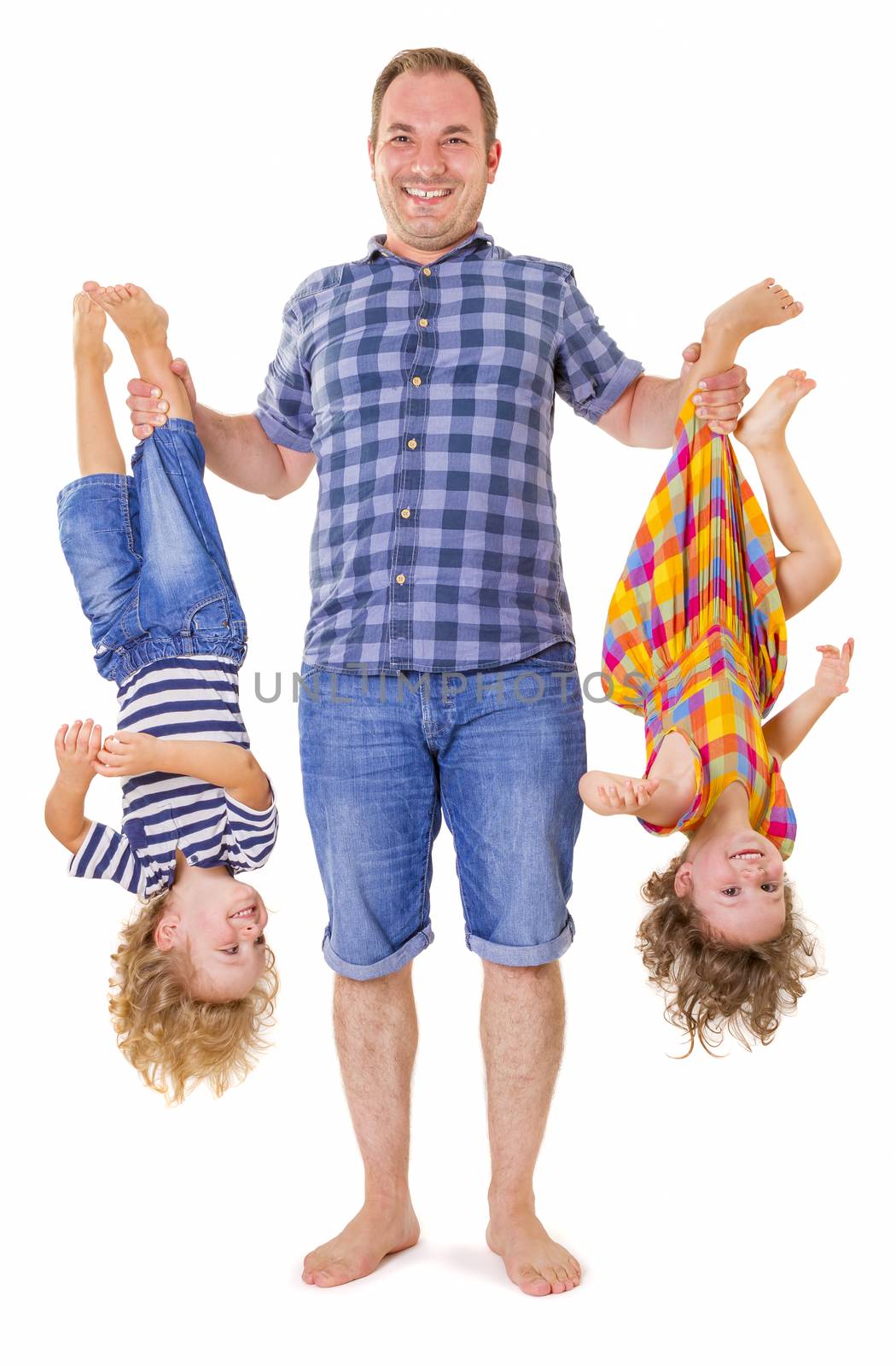 Happy father holding his smiling children upside down isolated on white background.