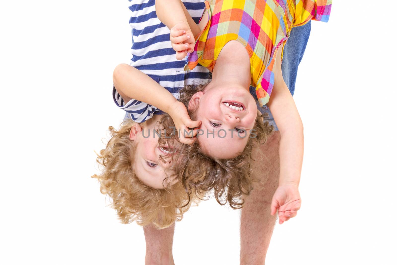 Father hands holding his smiling and playful children upside down on white background.