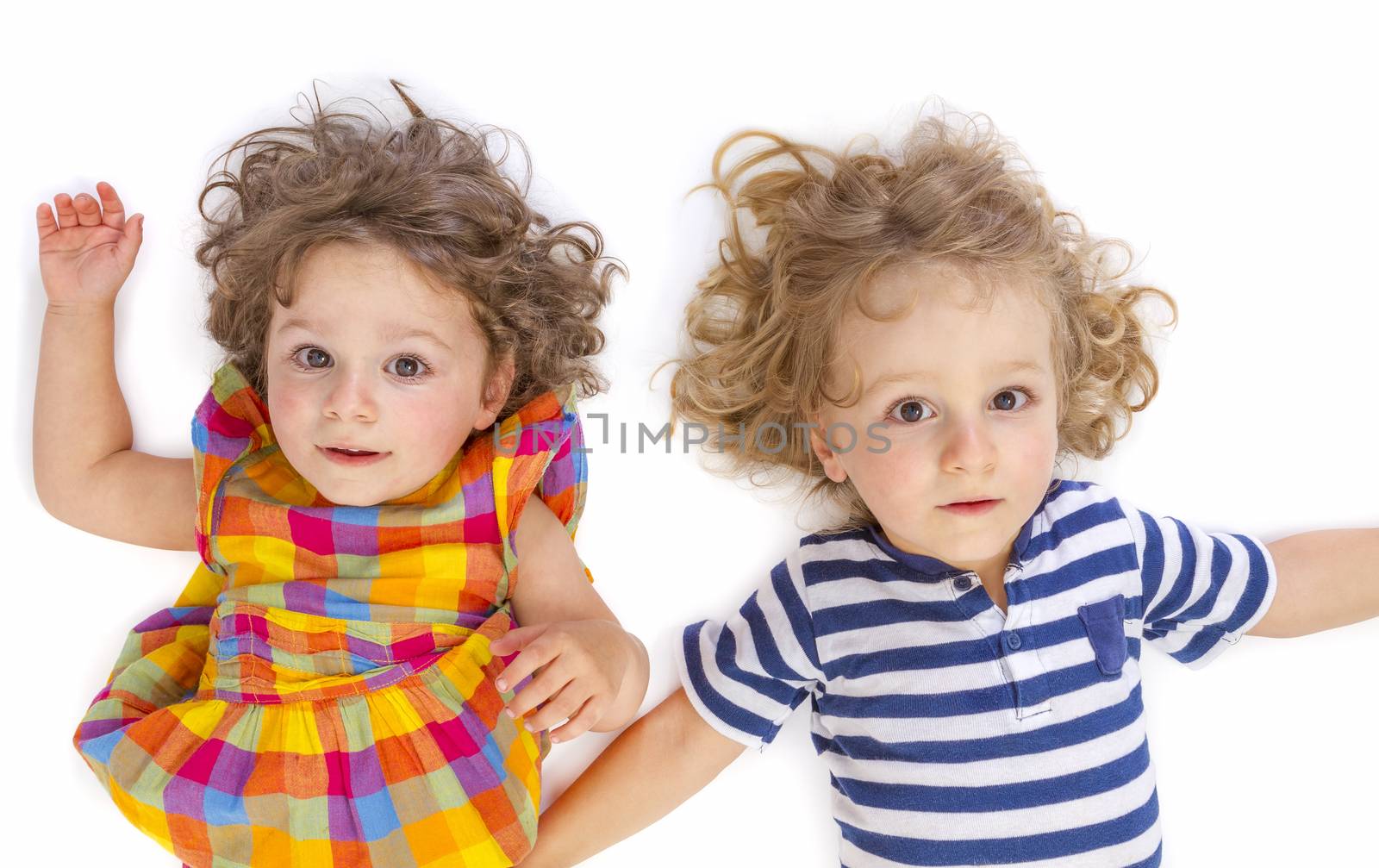  Little boy and girl looking at camera on white background