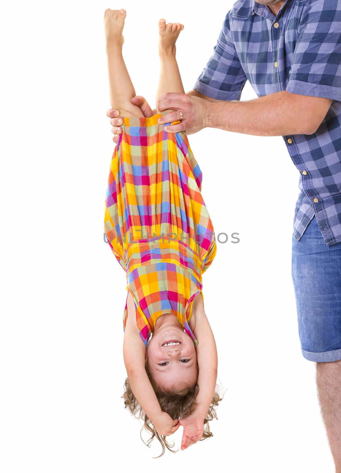 Father holding his little daughter upside down. Trust concept.