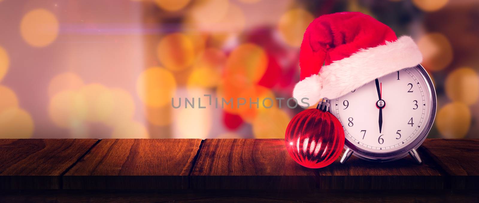 Christmas clock against focus on red christmas baubles