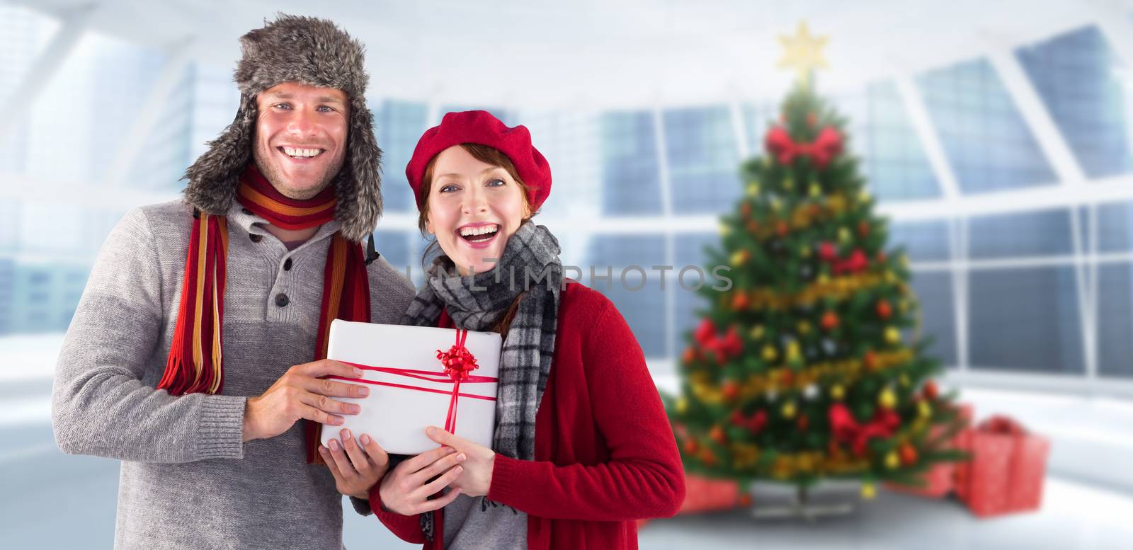 Composite image of couple smiling and holding gift by Wavebreakmedia