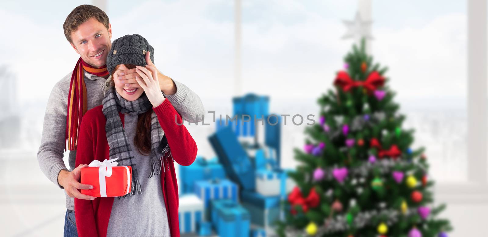Man giving woman a present against home with christmas tree