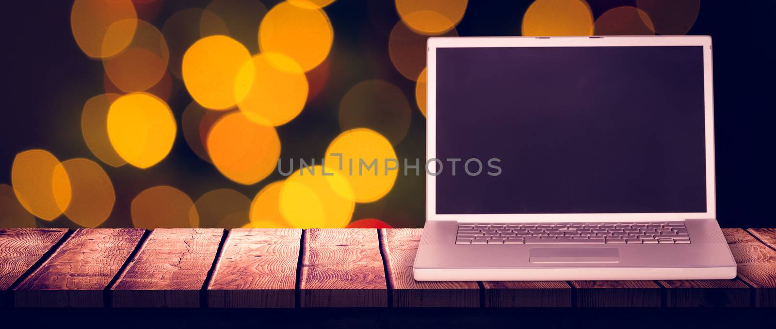 Laptop against desk with christmas tree in background