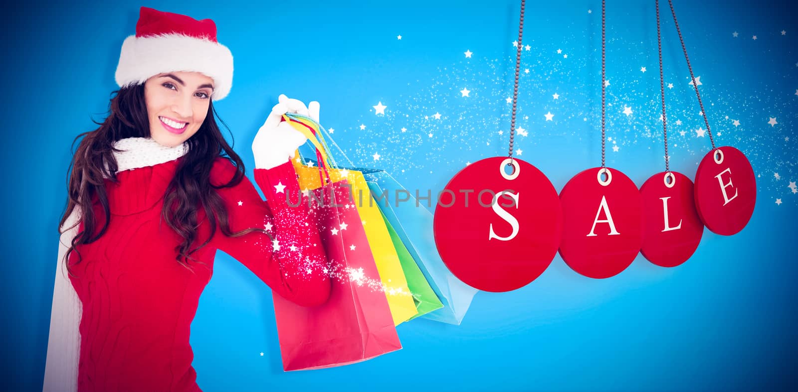 Composite image of festive brunette in winter wear holding shopping bags by Wavebreakmedia