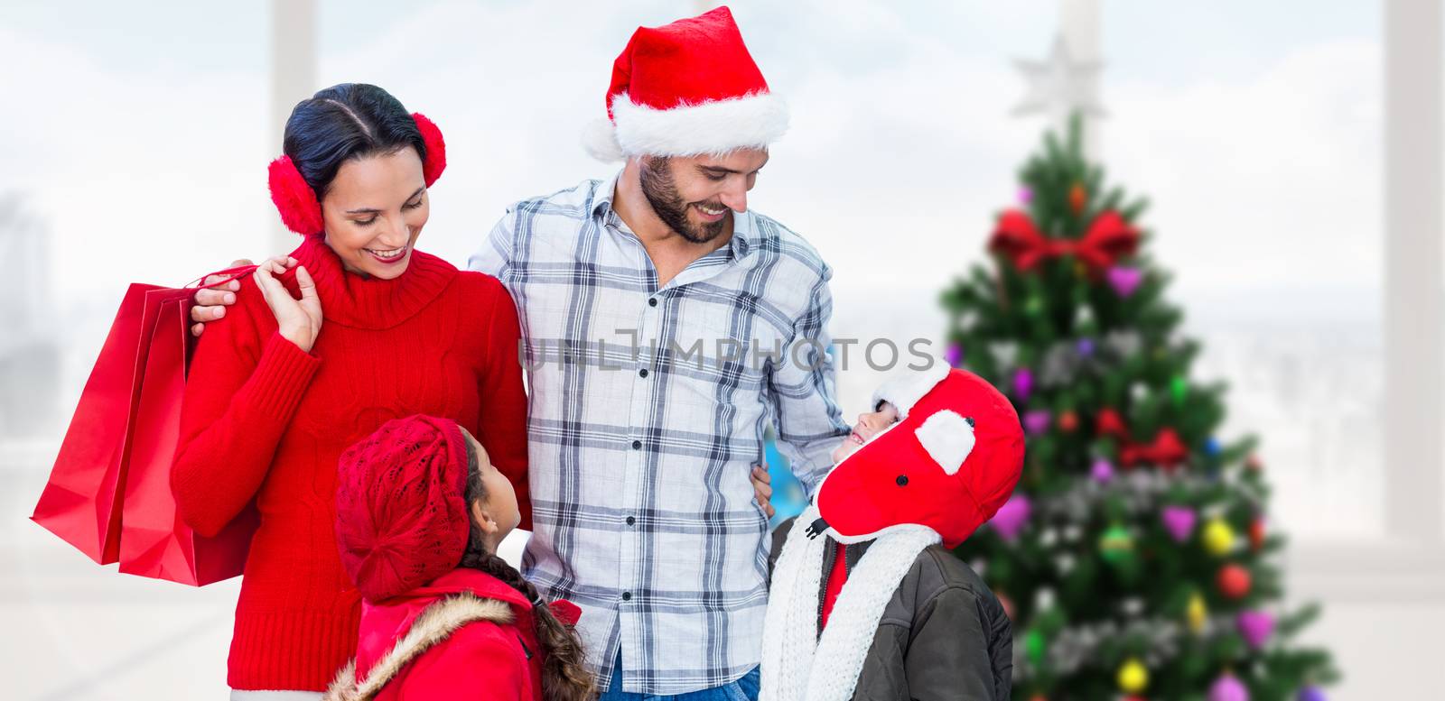 Happy family looking at each other  against home with christmas tree