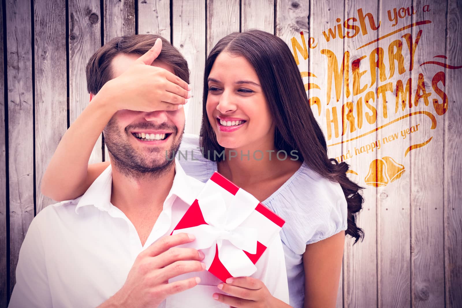 Composite image of woman surprising boyfriend with gift by Wavebreakmedia