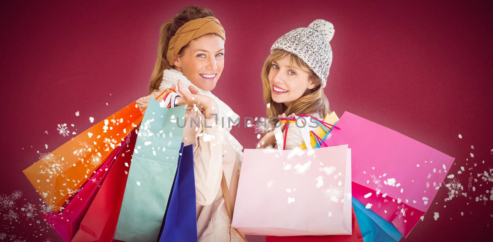 Beautiful women holding shopping bags looking at camera  against red background