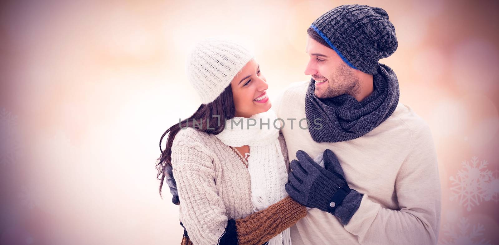 Young winter couple against glowing christmas background