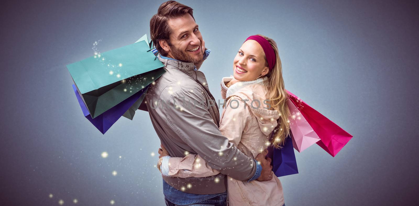 Composite image of smiling couple with shopping bags embracing by Wavebreakmedia