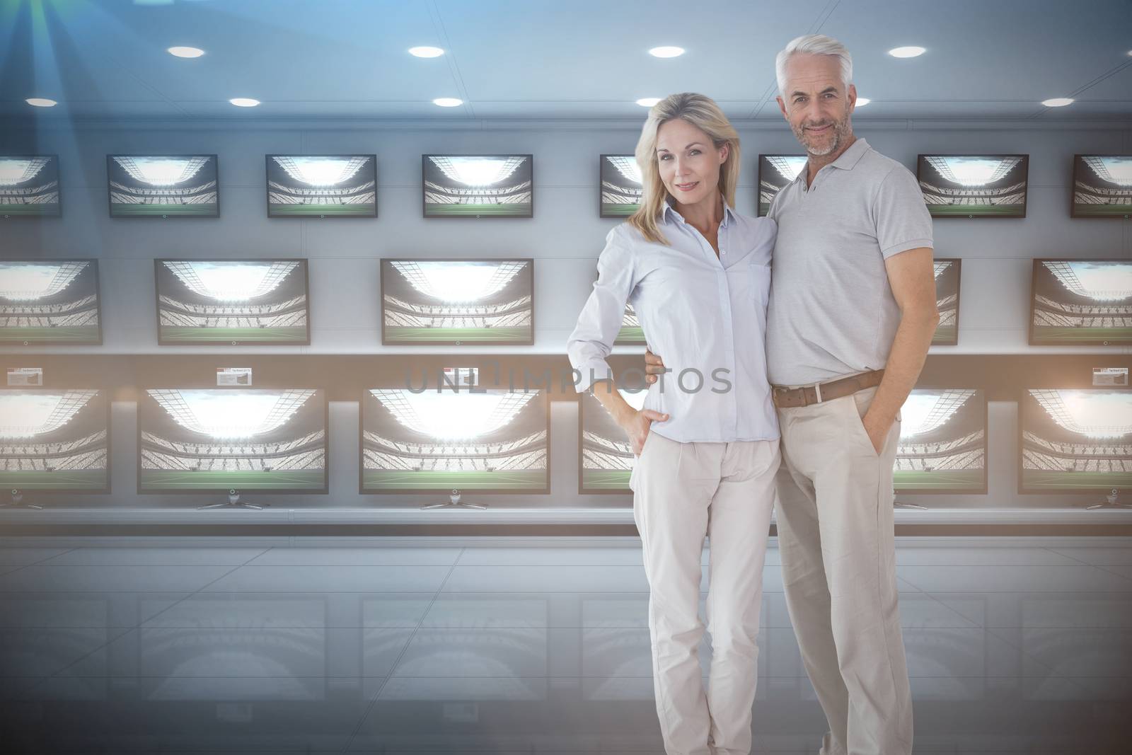 Couple standing with hands in pocket against televisions for sale