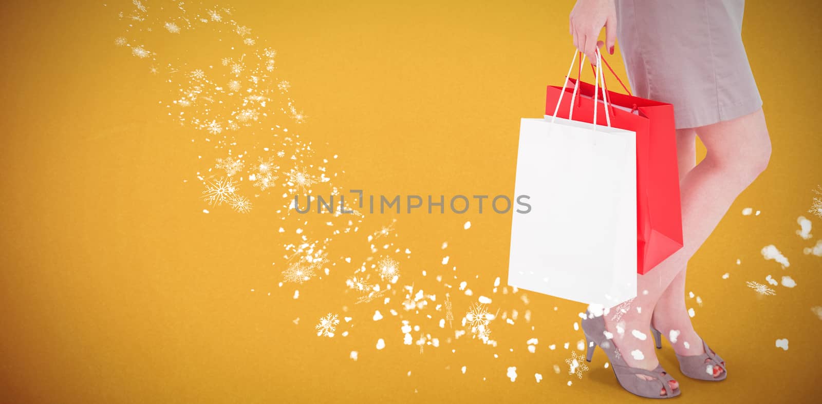 Elegant brunette posing with shopping bags against orange background