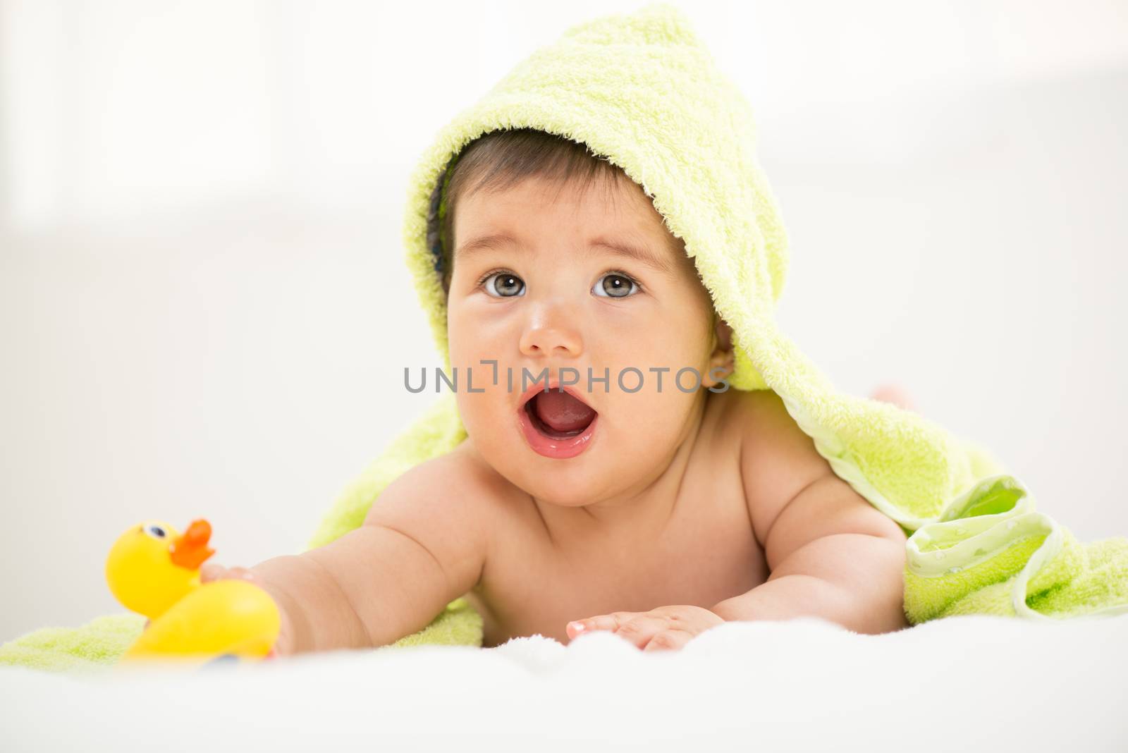 Cute baby boy lying under a towel