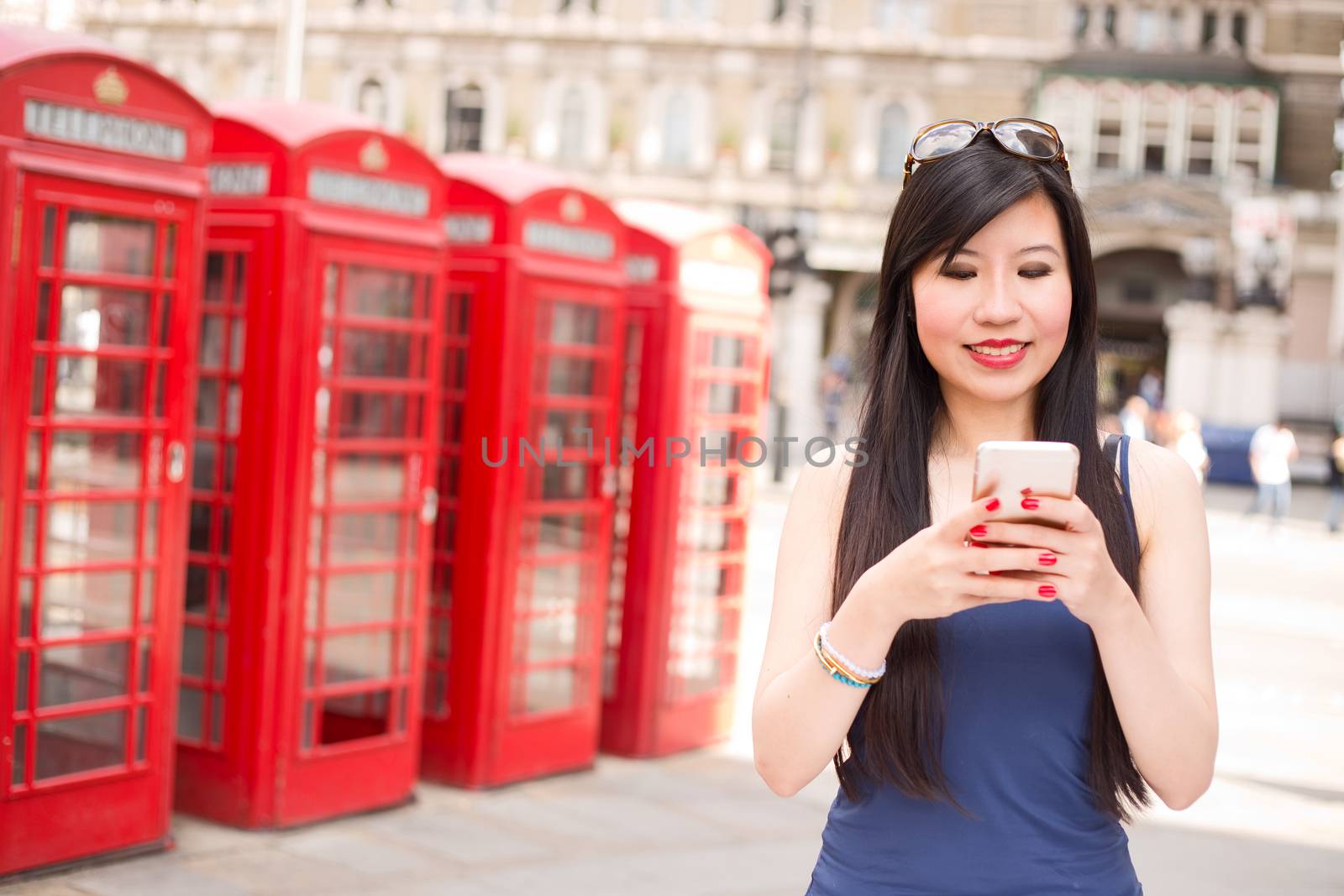 japanese woman sending a text on her mobile phone in London