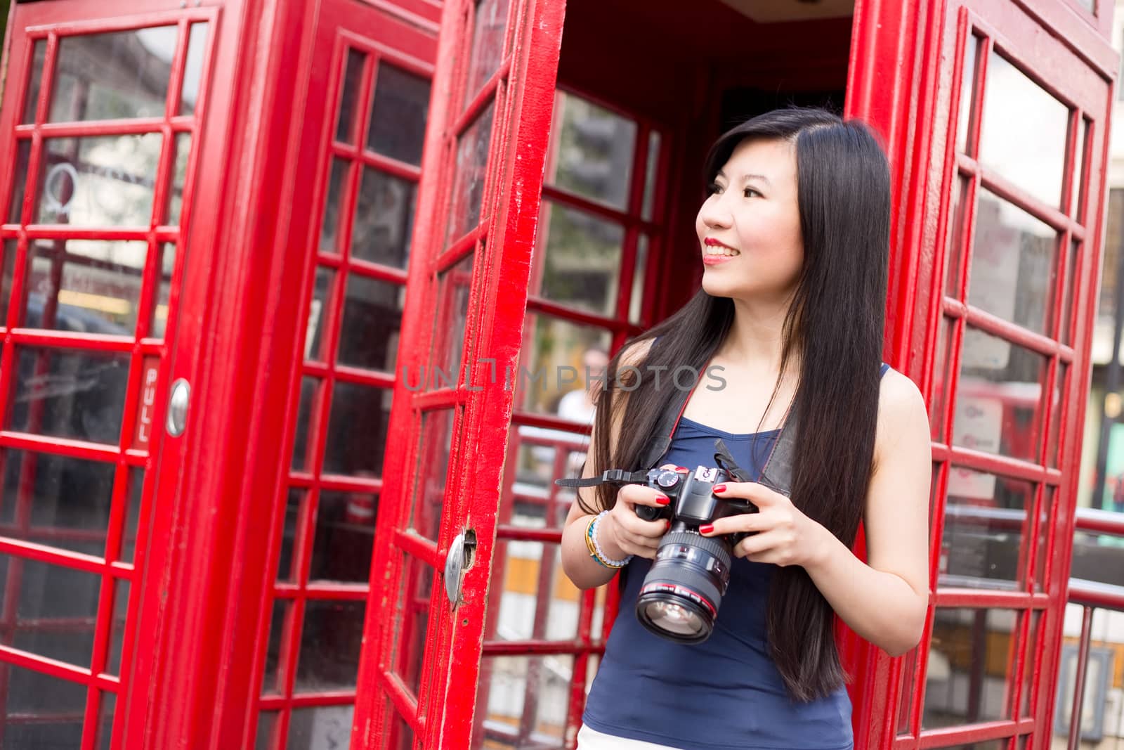 Japanese tourist in London holding a camera