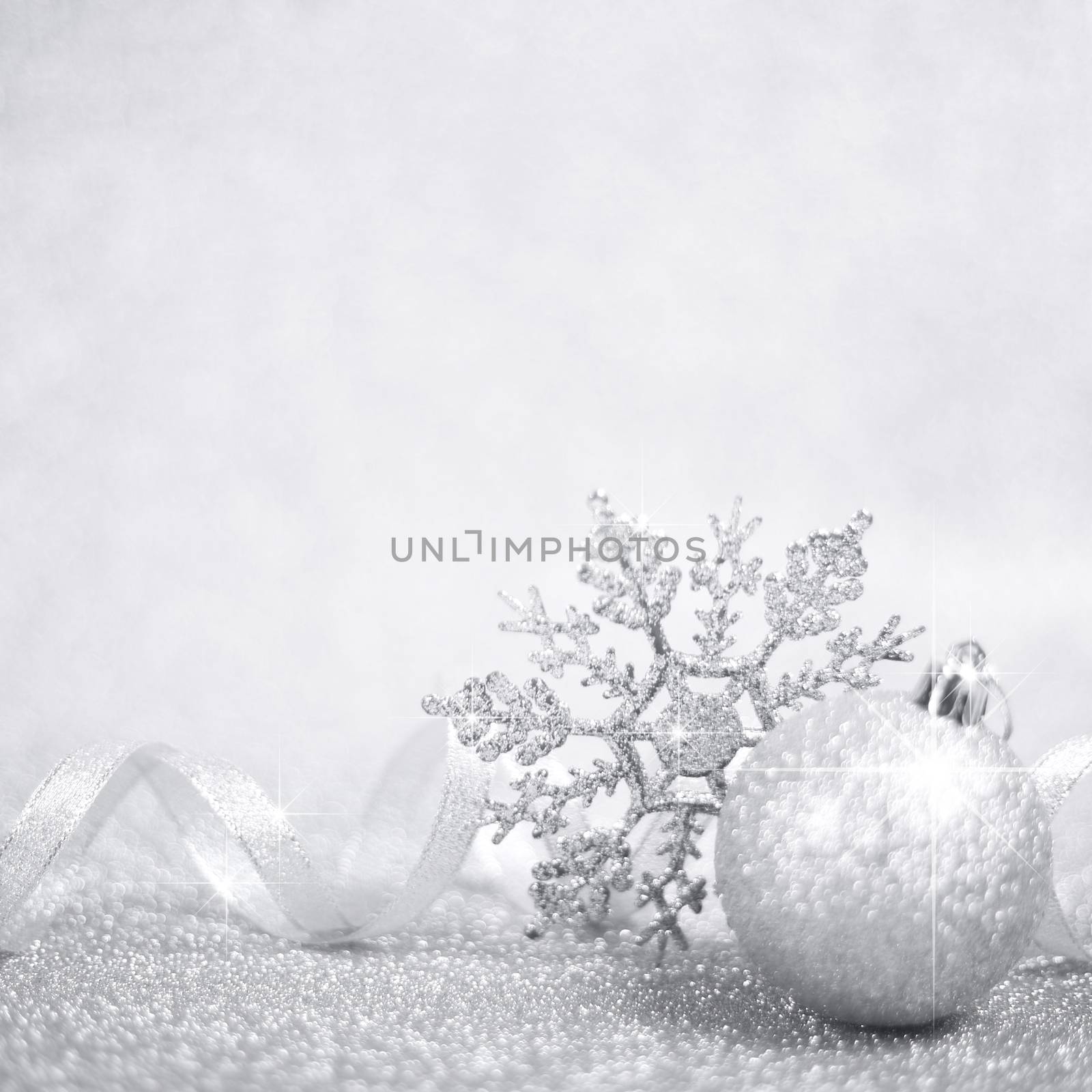 Silver christmas balls and snowflakes on shining glitter background with copy space