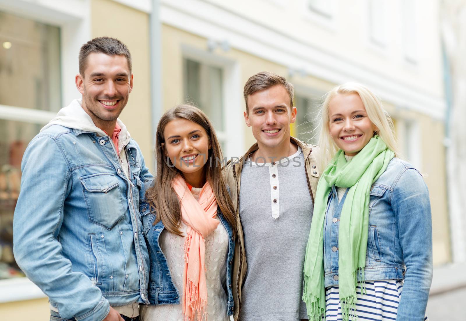 group of smiling friends in city by dolgachov