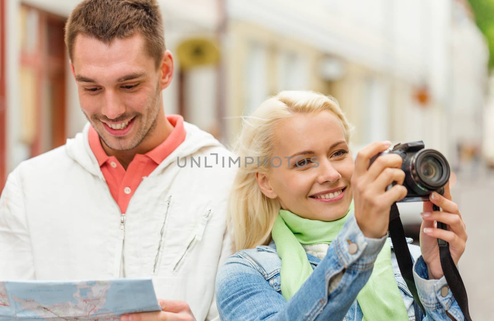 smiling couple with map and photocamera in city by dolgachov