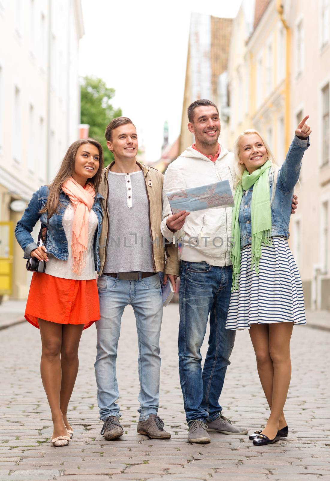 travel, vacation, technology and friendship concept - group of smiling friends with map and photocamera exploring city