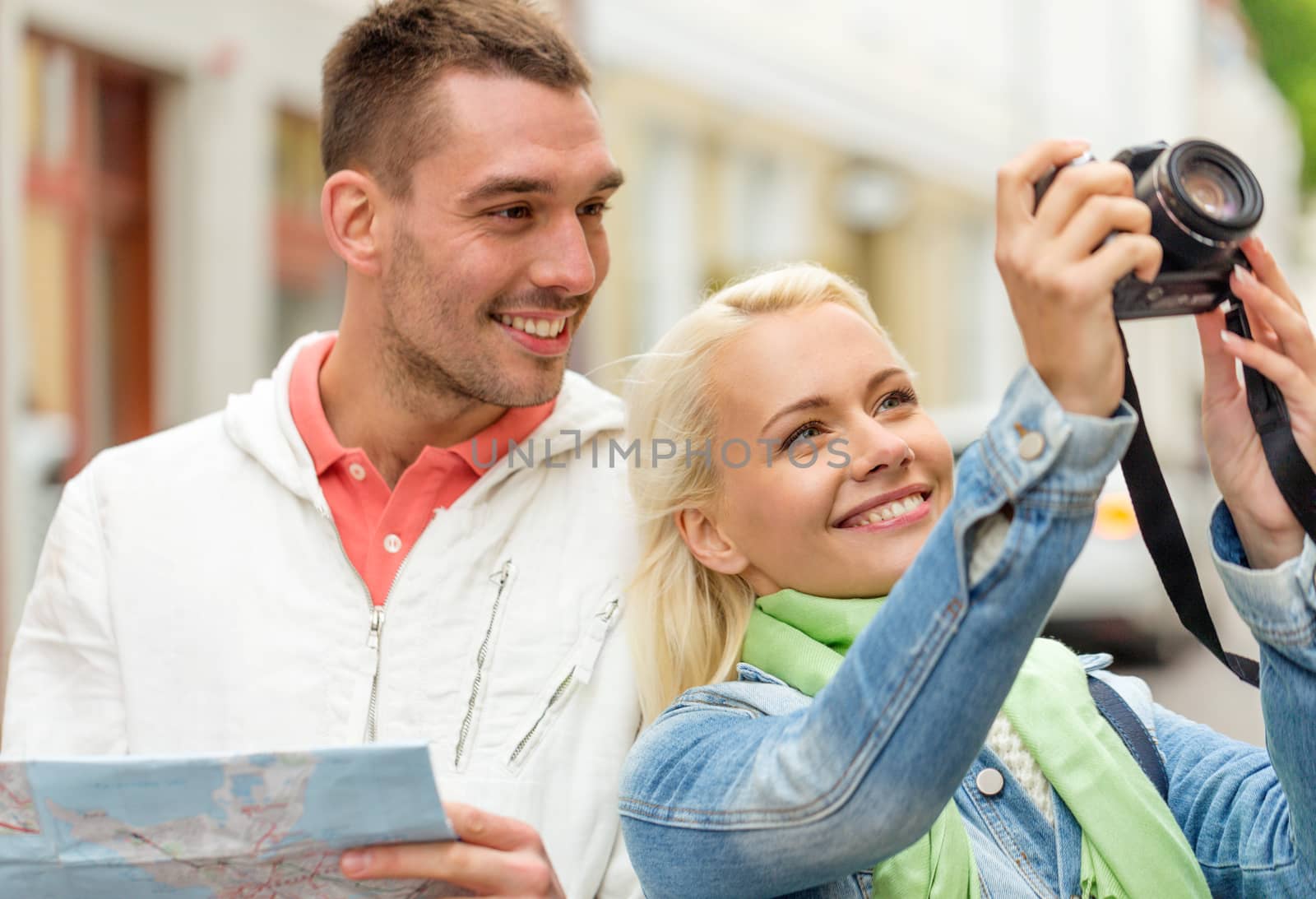 travel, vacation, technology and friendship concept - smiling couple with map and photocamera exploring city