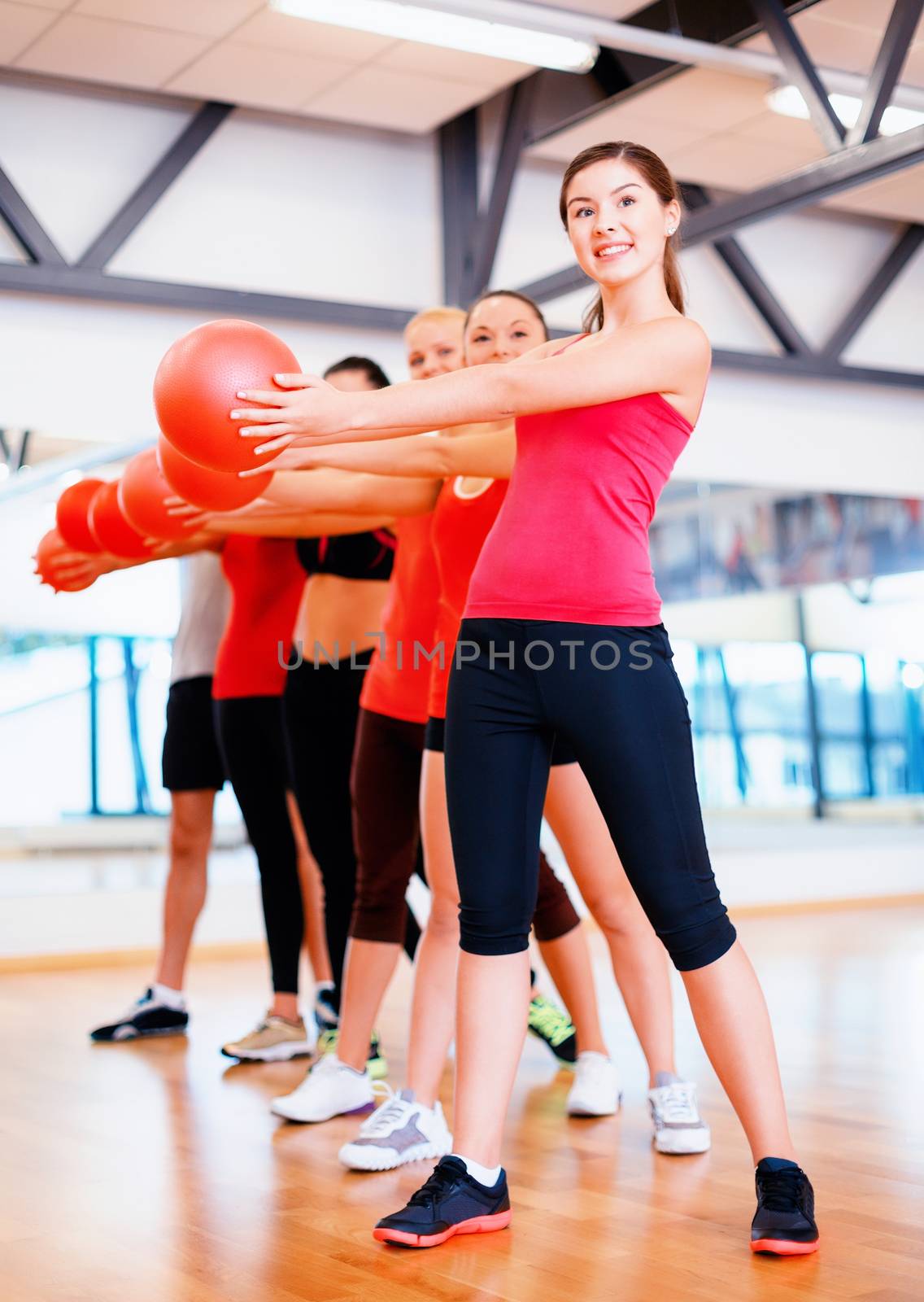 fitness, sport, training, gym and lifestyle concept - group of smiling people working out with stability balls in the gym