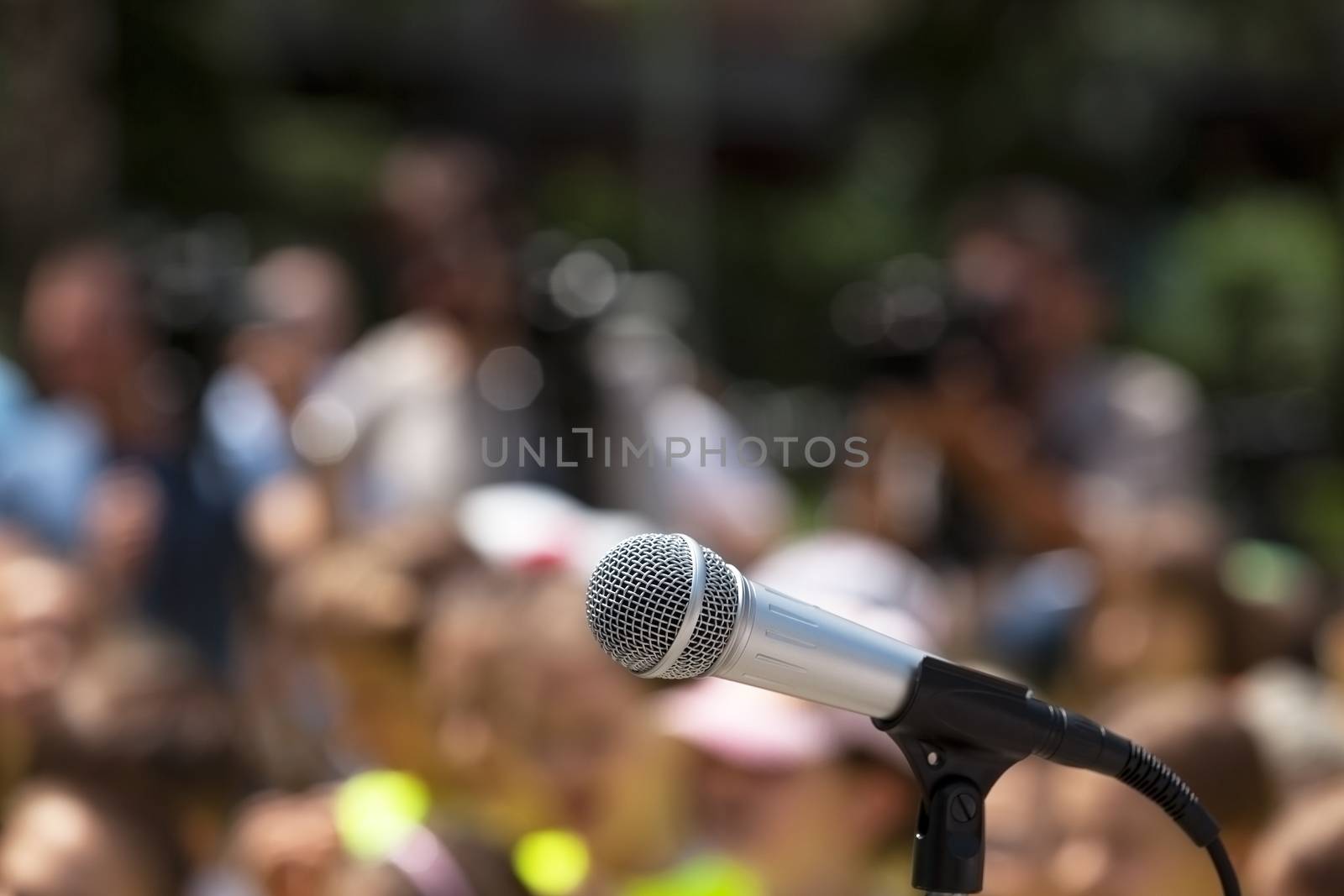 Microphone in focus against blurred group of people