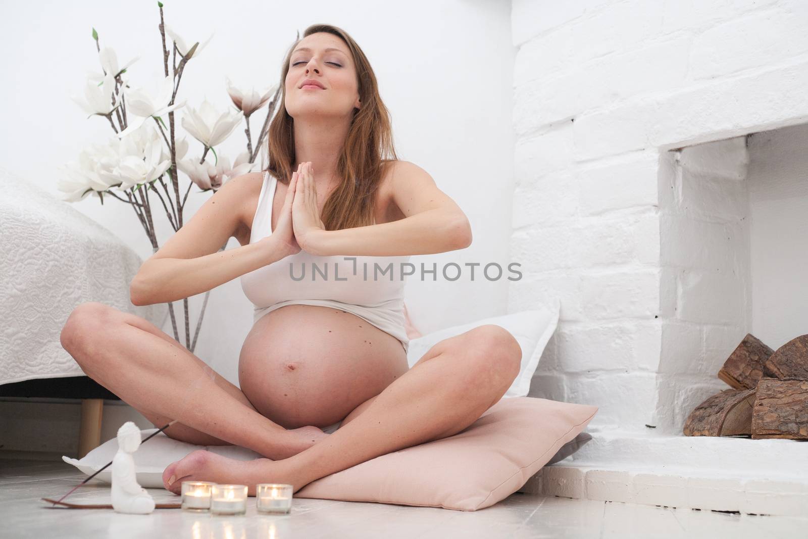 Young new mother is meditating on the ground of her bedroom