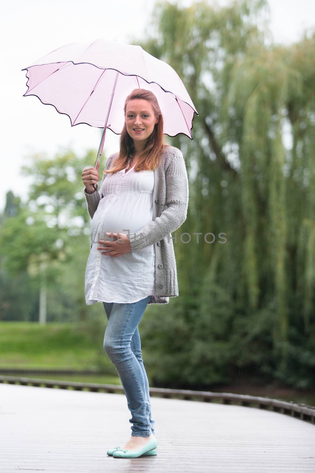 Pregant woman outside with umbrella by DNFStyle