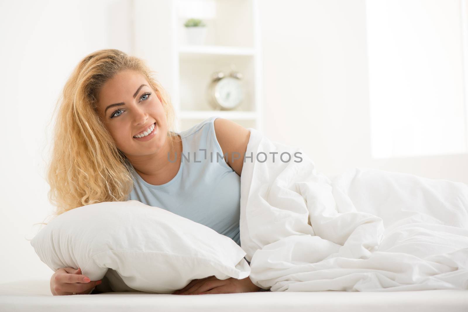 Young woman lying in bed in the morning.