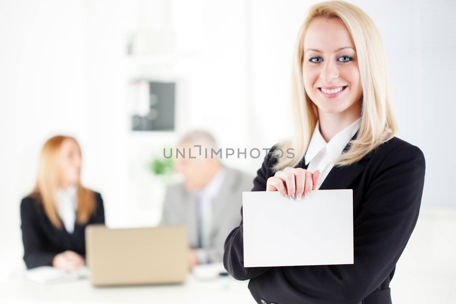 Beautiful young businesswoman holding Blank business card in the office. Looking at camera. Selective Focus.