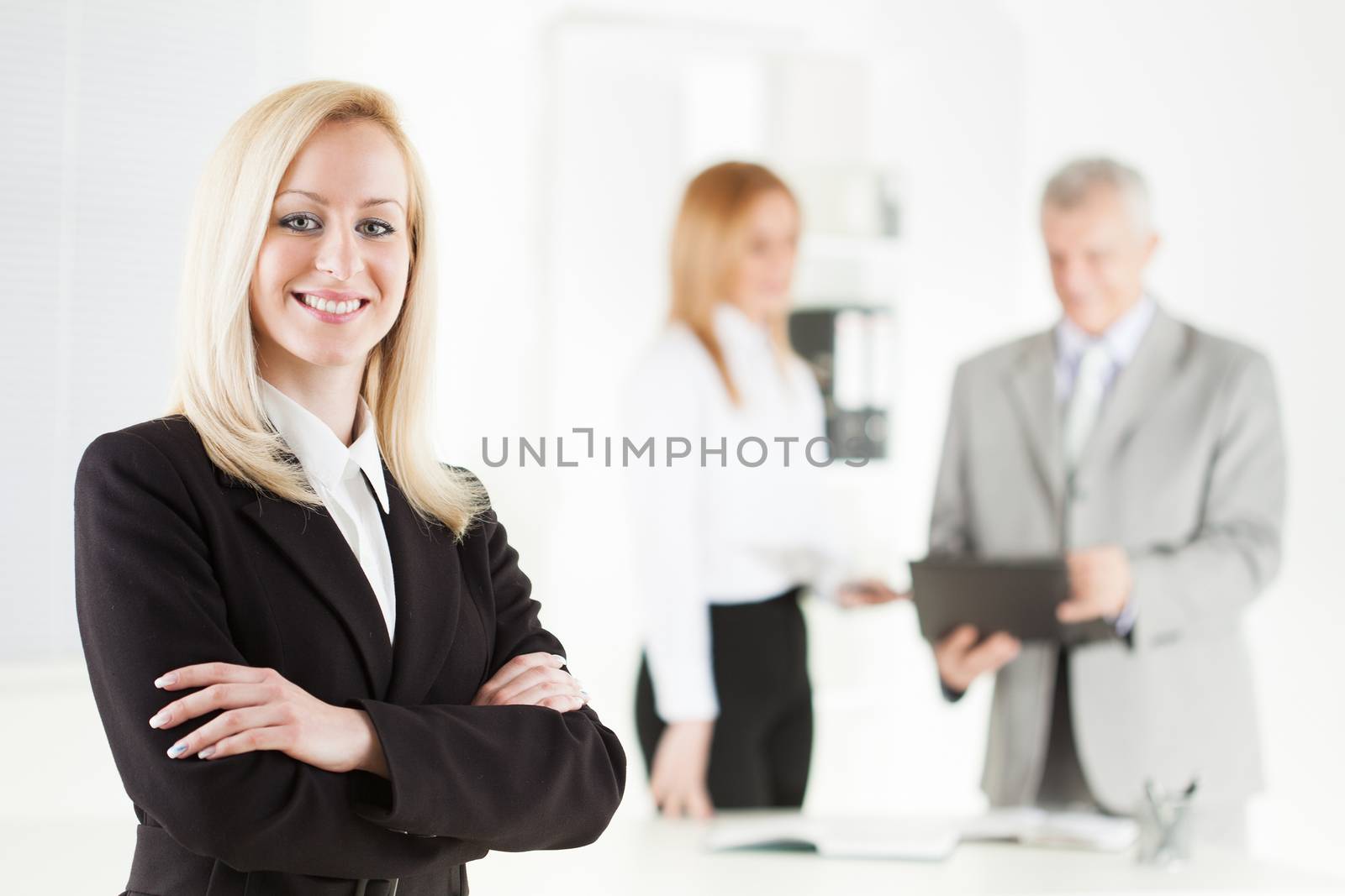Beautiful young businesswoman with Arms Crossed in the office. Looking at camera. Selective Focus.