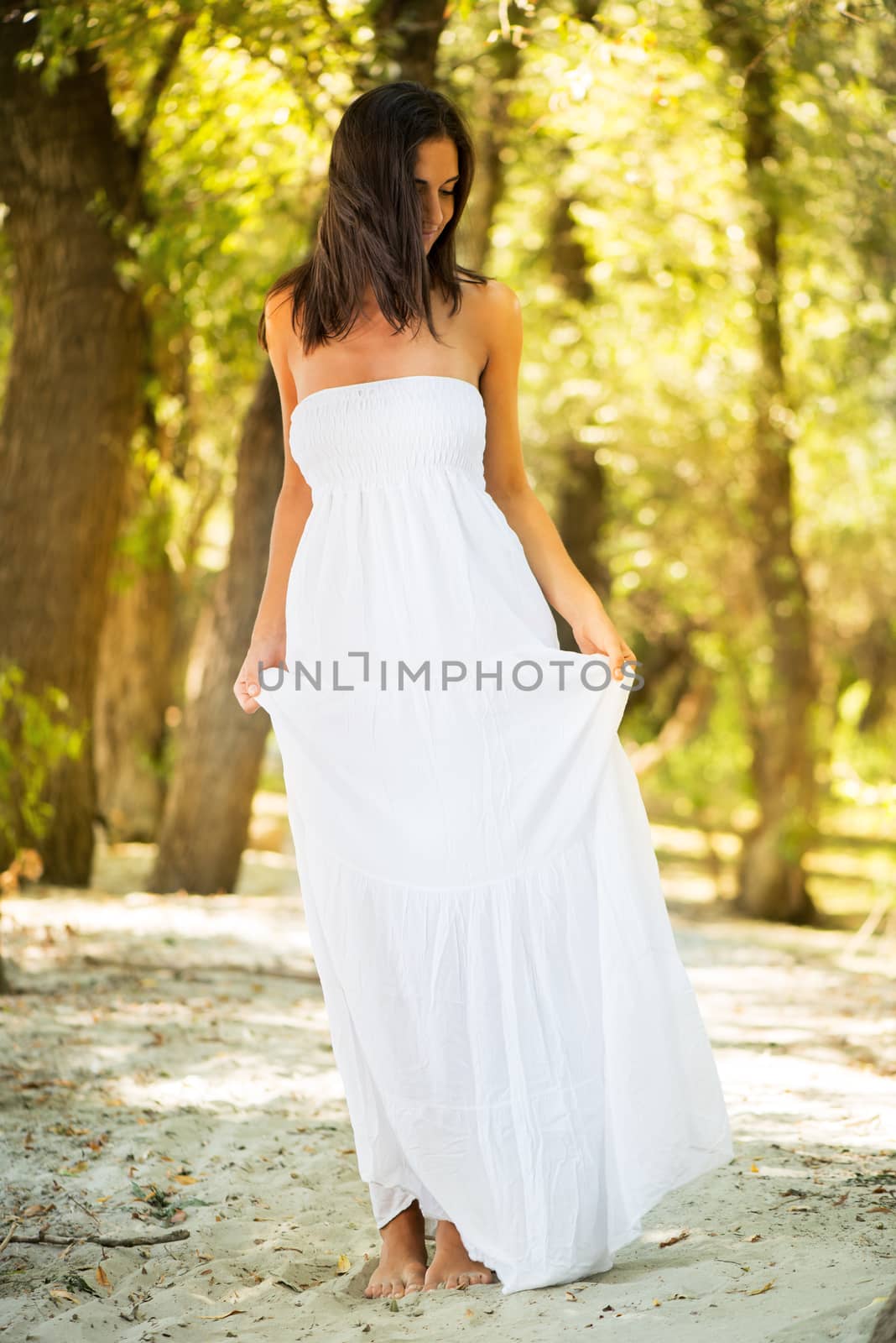 Young beautiful woman in white dress relaxing in the nature.