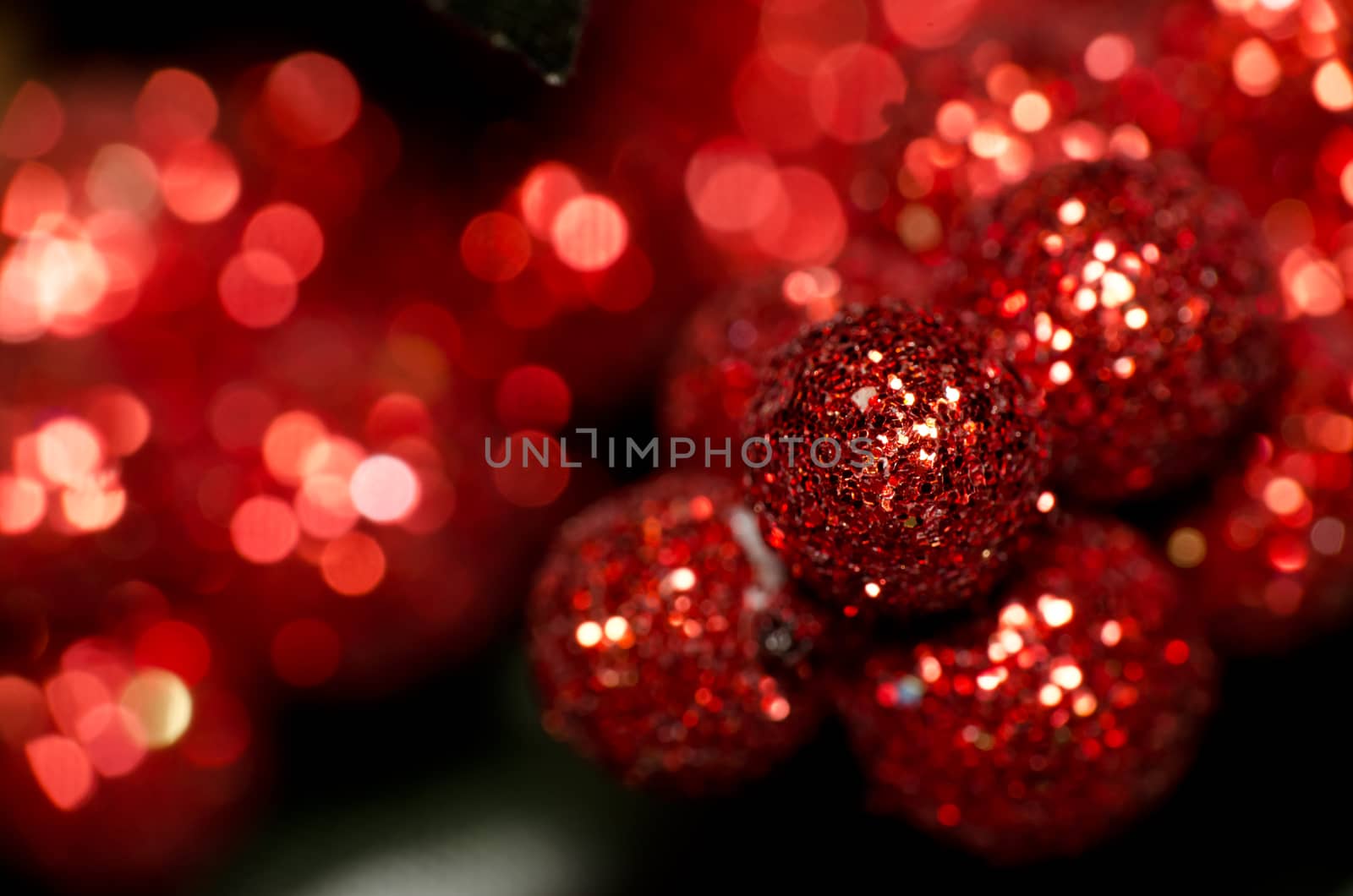 Christmas red shining baubles against red defocused background