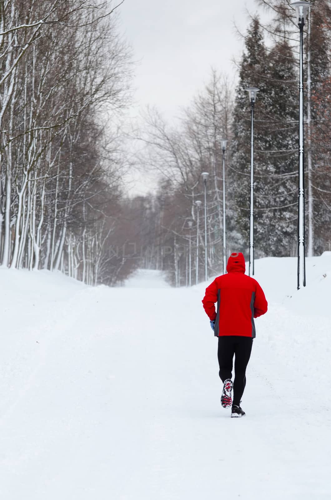 Man running in winter park by Attila
