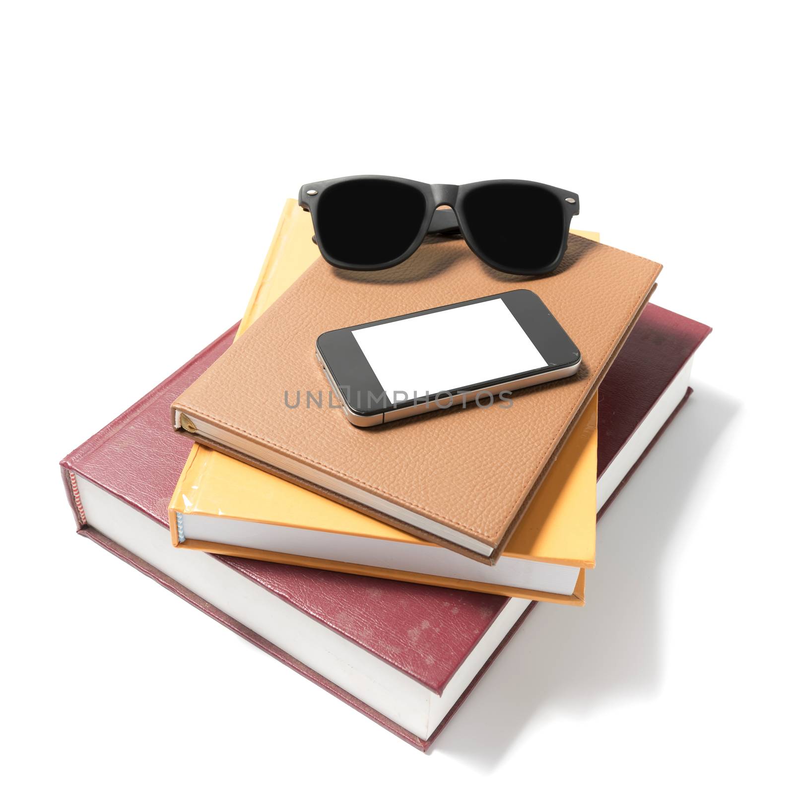 sunglasses smartphone and stack of book isolated on white background