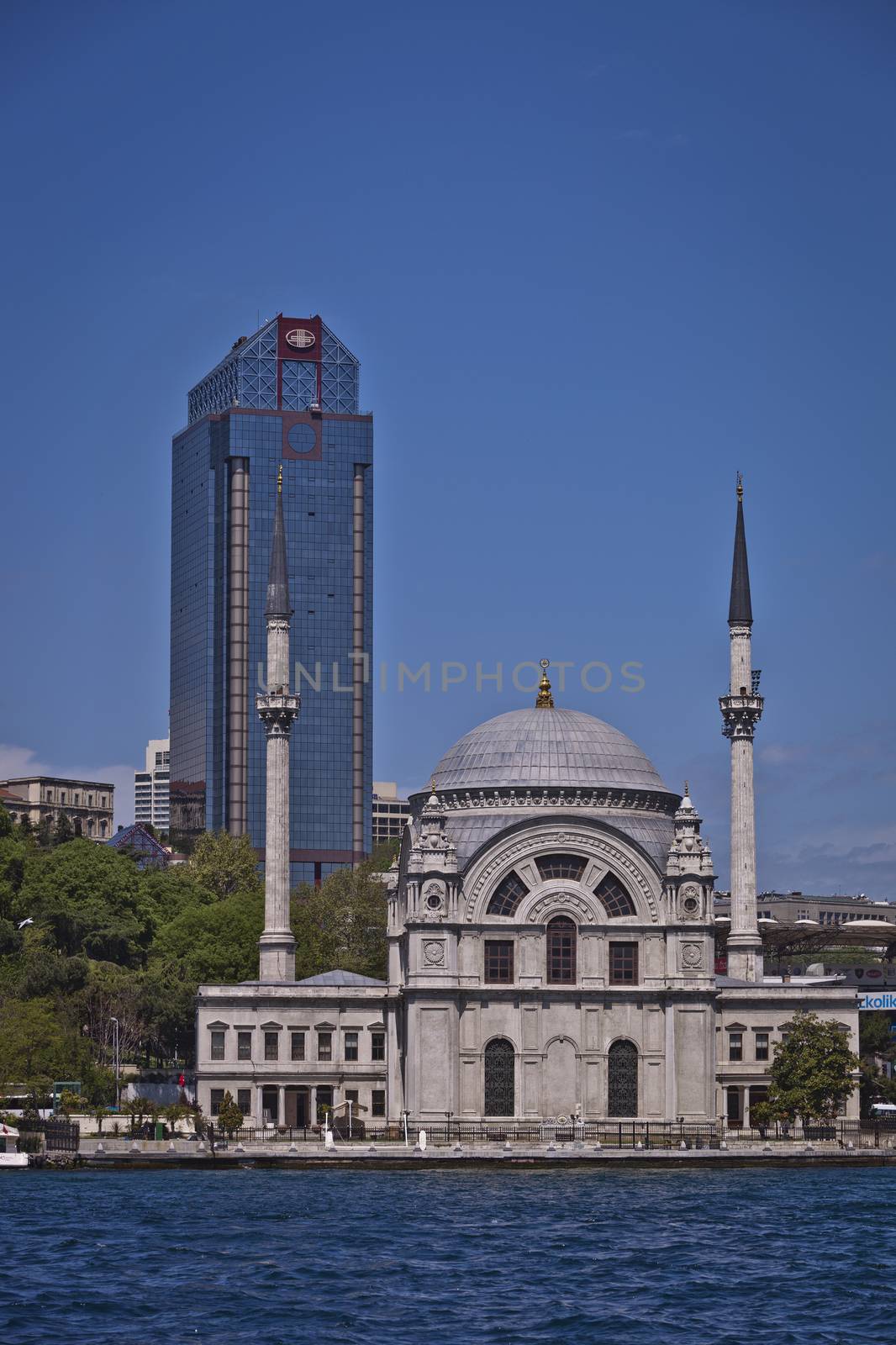 ISTANBUL, TURKEY – APRIL 27:  Traditional Dolmabahce Mosque on the Bosphorus in Istanbul with modern office building behind on April 27, 2012 in Istanbul, Turkey. 